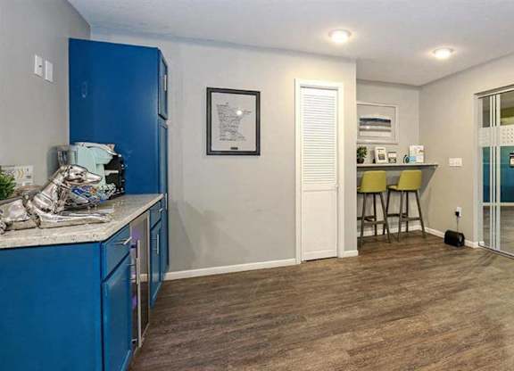 A kitchen with blue cabinets and a white fridge.