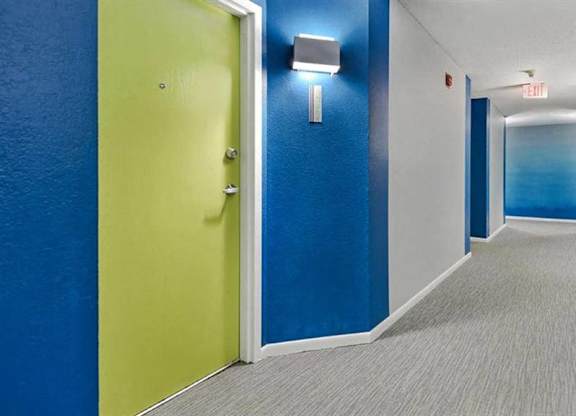 A hallway with a yellow door and blue walls.