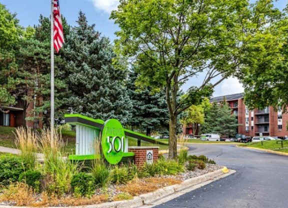 A green sign with the number 501 is in the foreground of a street scene.