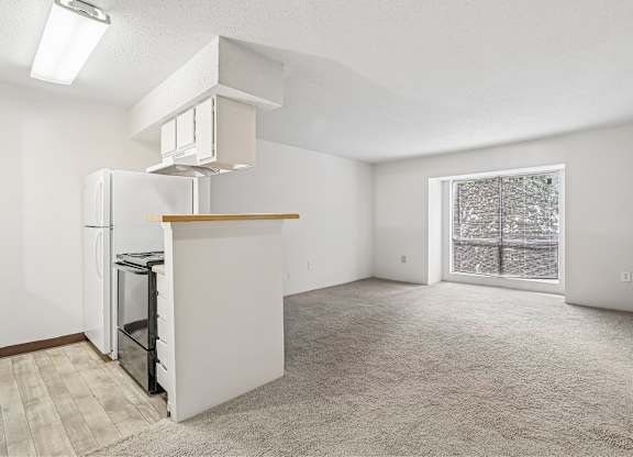 A white kitchen with a refrigerator, oven, and microwave.