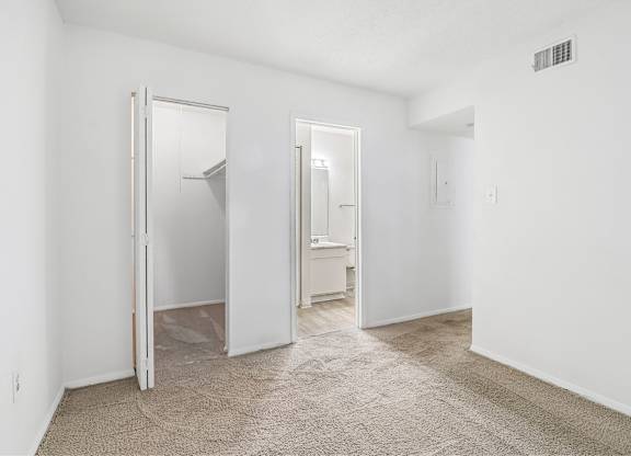 A white room with a carpeted floor and a white door.