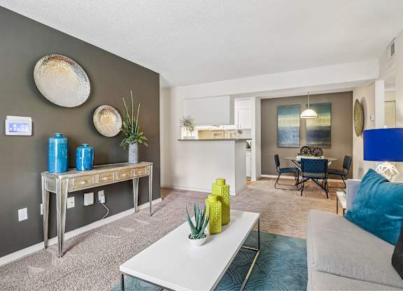 A living room with a grey couch, a white coffee table, and a blue lamp.