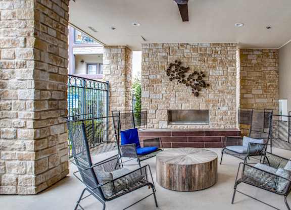 Resident clubhouse with fireplace and lounge seating at Twin Creeks Crossing, apartments in Allen