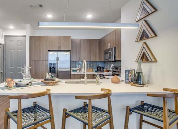 Modern kitchen with large island and stainless steel appliances at Twin Creeks Crossing, apartments in Allen, TX