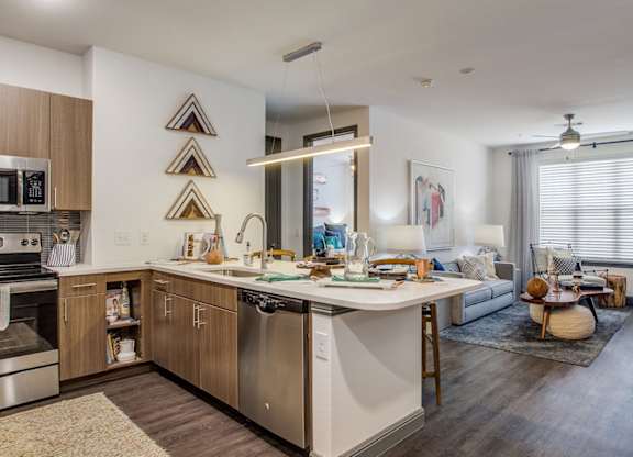 Apartment kitchen with stainless steel appliances and spacious island at Twin Creeks Crossing in Allen, TX