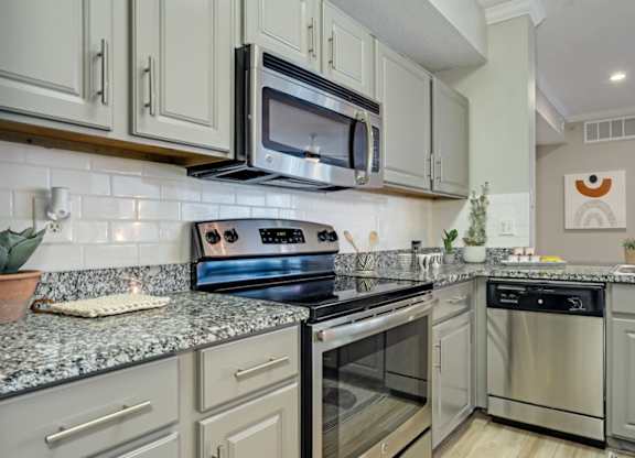 Kitchen with granite countertops and stainless steel appliances at The Lana, Dallas apartments