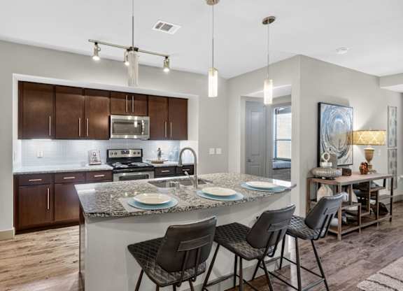 Kitchen with stainless steel appliances at The Carson at Twin Creeks, Allen apartments