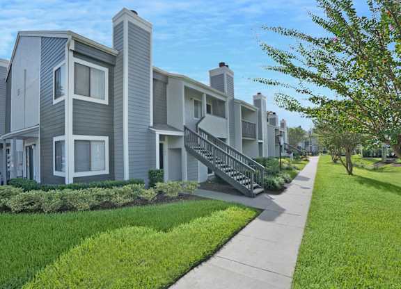 A row of modern houses with a sidewalk in front.