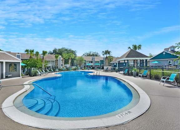 A large outdoor swimming pool with a white border and blue water.