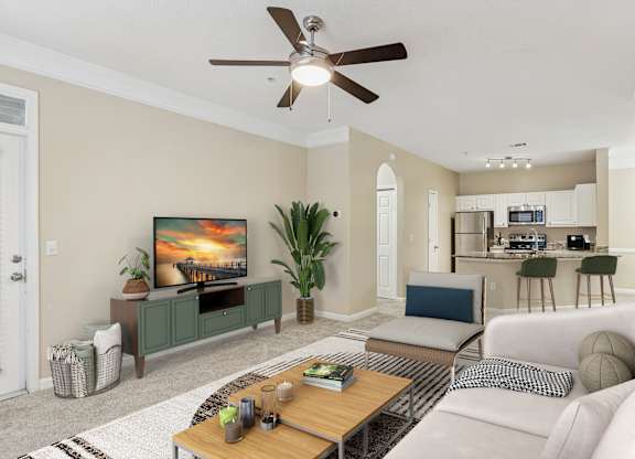 A living room with a television, couch, and a ceiling fan.