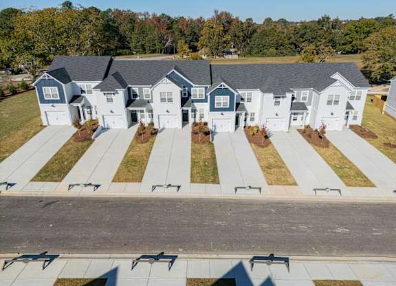 an aerial view of a neighborhood of white houses with gray roofs