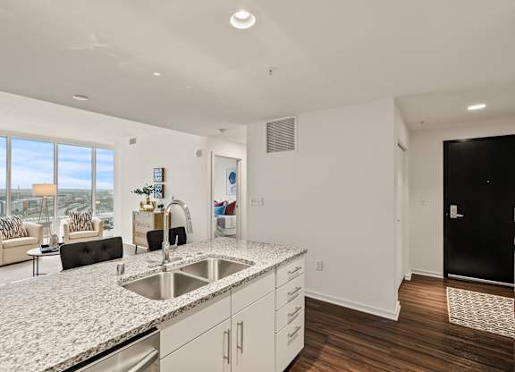 A modern kitchen with a large island and a view of the city.