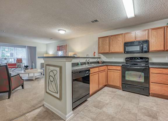 A kitchen with a black oven and microwave.