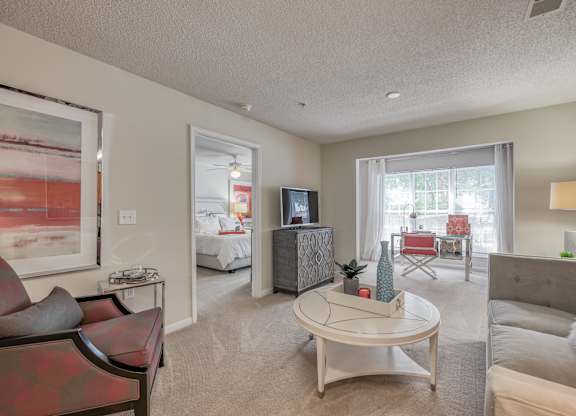 A living room with a red couch and a white coffee table.