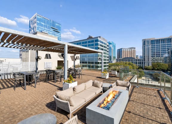 A rooftop patio with a fire pit and seating area.