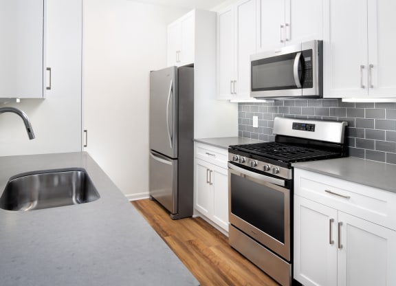 Kitchen with upper and lower cabinets with full appliance suite