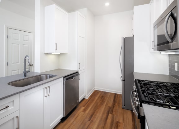 Kitchen with upper and lower cabinets with full appliance suite