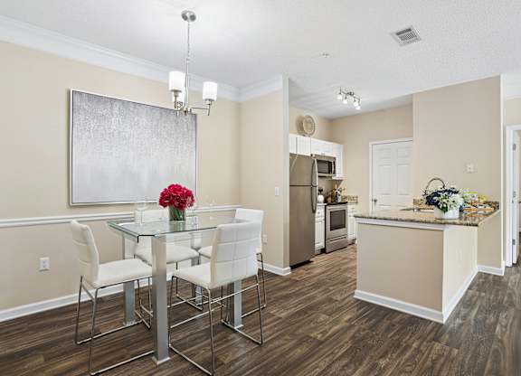 A dining room with a glass table and chairs.