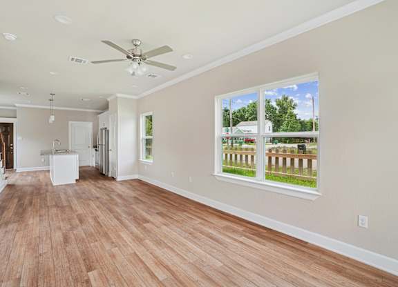 A room with a ceiling fan and a large window.