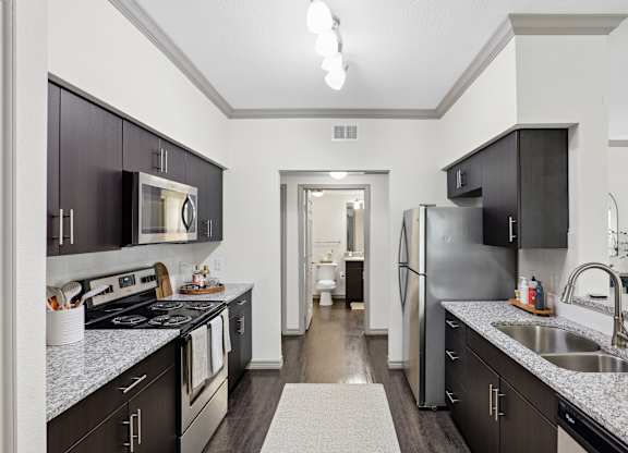 A kitchen with dark brown cabinets and a white counter top.