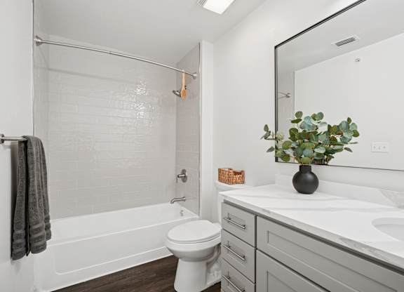 A bathroom with a white toilet, a white sink, and a white bathtub.