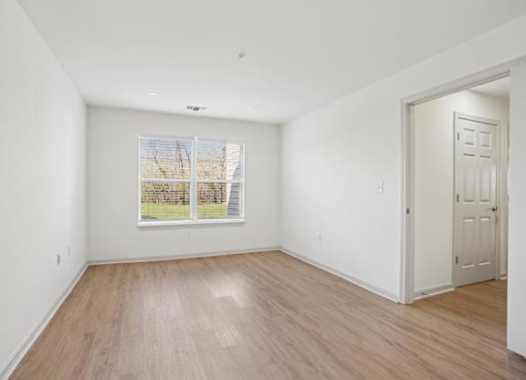 Empty room with wooden floor and white walls.