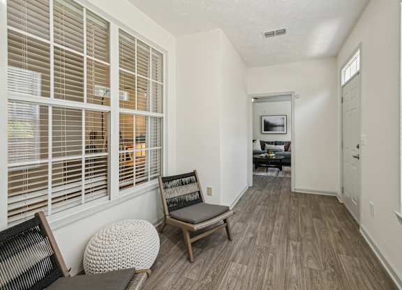 A room with a chair and a table with a television on the wall.
