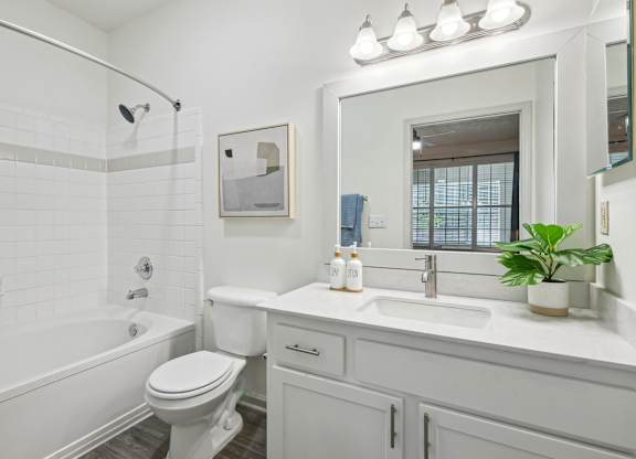 A white bathroom with a toilet, sink, and tub.