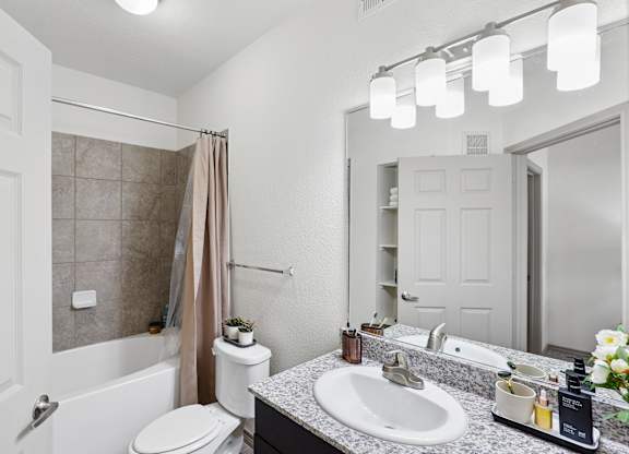 A bathroom with a toilet, sink, and shower.