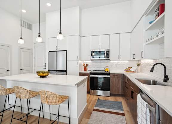 A kitchen with a white countertop and a stainless steel oven.