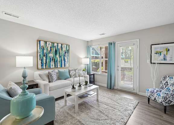 A living room with a white couch, a coffee table, and a painting on the wall.