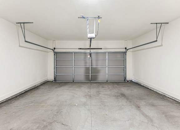 the inside of a garage with white walls and a concrete floor