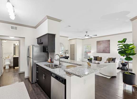 A modern kitchen with a refrigerator, sink, and cabinets.