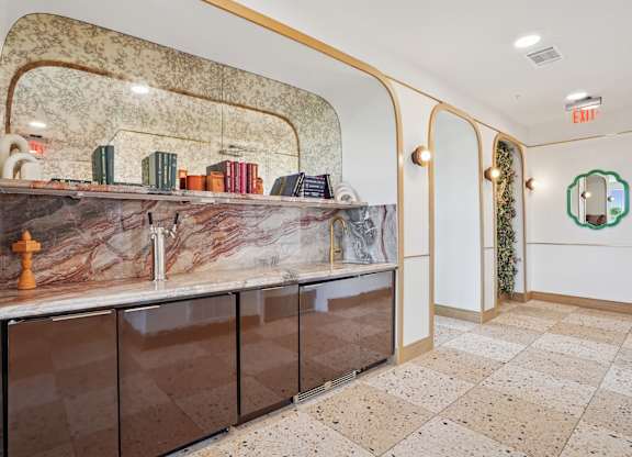 A kitchen with a marble counter top and a brown cabinet.