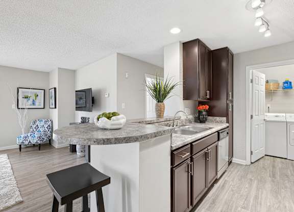 A kitchen with a white counter top and brown cabinets.