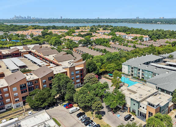 A bird's eye view of a residential area with a swimming pool and a bridge.