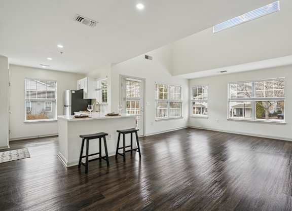 A spacious kitchen with a bar area and wooden flooring.