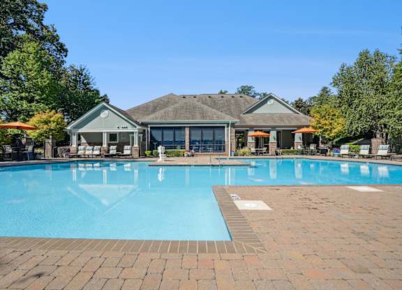 A large swimming pool in front of a house.