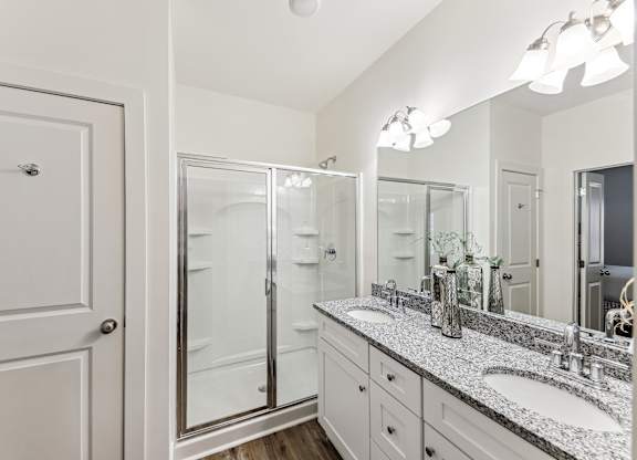 a bathroom with two sinks and a shower