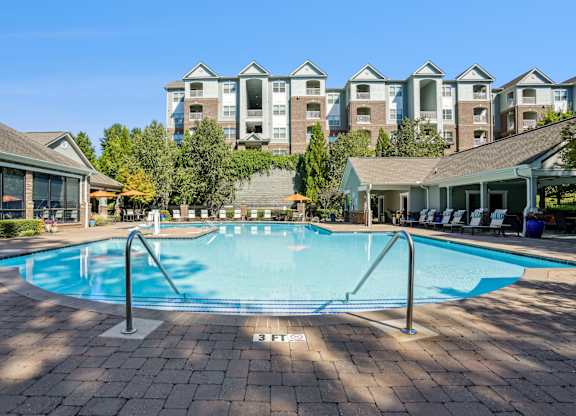 A large swimming pool in front of apartment buildings.
