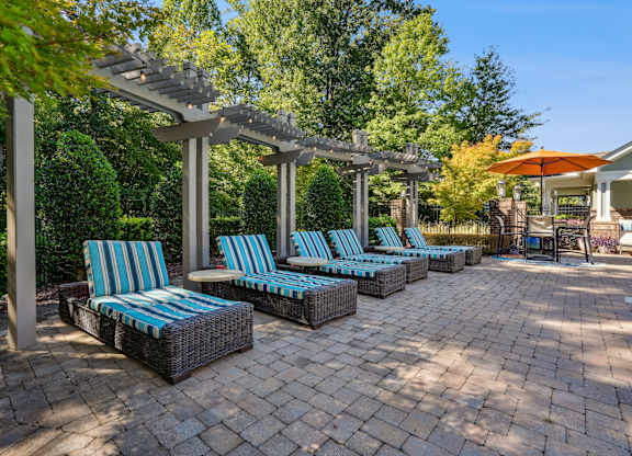 A patio with blue and white striped cushions on the chairs.