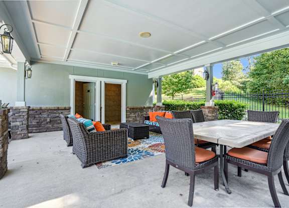 A patio with a table and chairs under a roof.