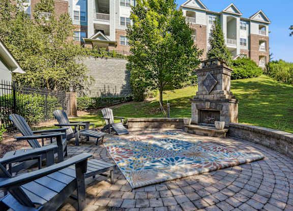 A patio with a table and chairs and a fireplace.