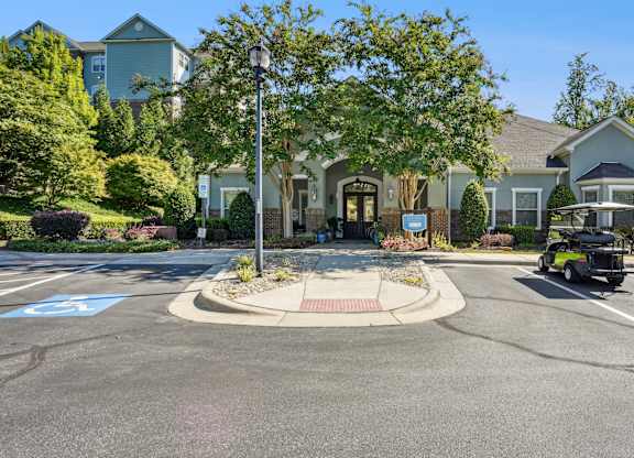 A parking lot with a roundabout and a building in the background.