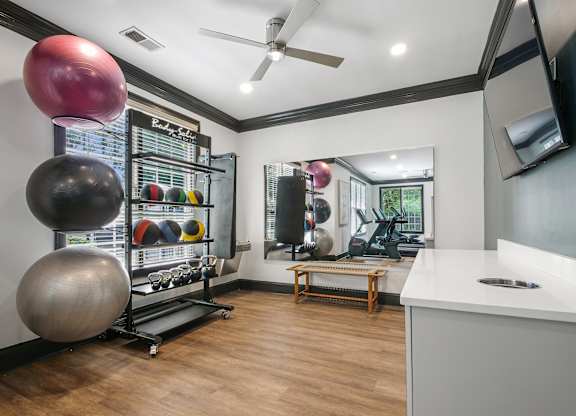 A gym room with a variety of exercise equipment.