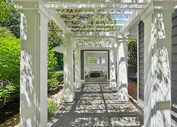 A white pergola with a black and white checkered floor.