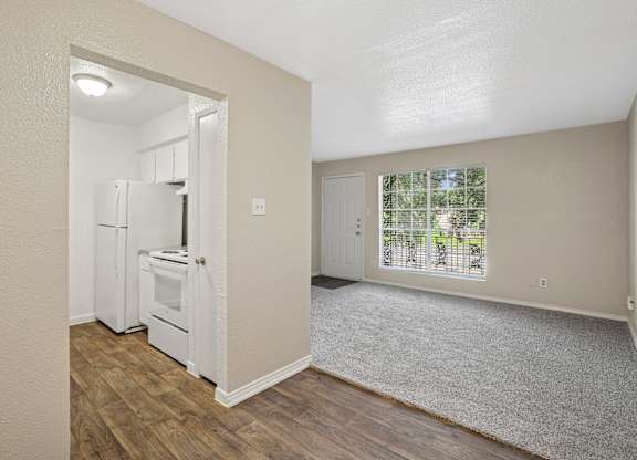 A kitchen with white appliances and a small dining area.