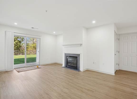 A room with a fireplace and a sliding glass door.