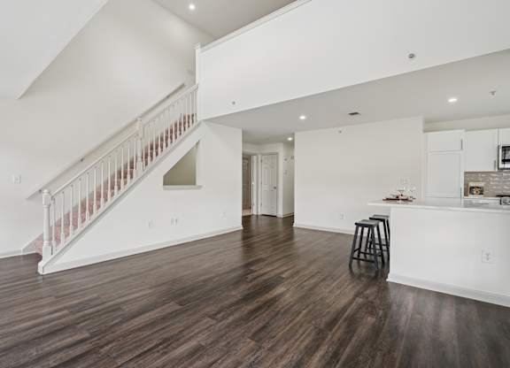 A living room with a bar area and a staircase.