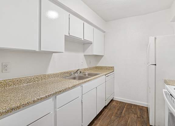 A kitchen with white cabinets and a granite countertop.